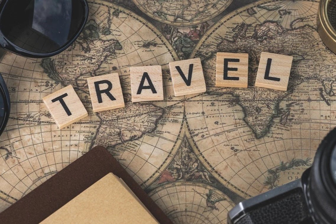 A world map with the word travel in wooden blocks. 