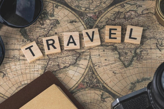 A world map with the word travel in wooden blocks. 